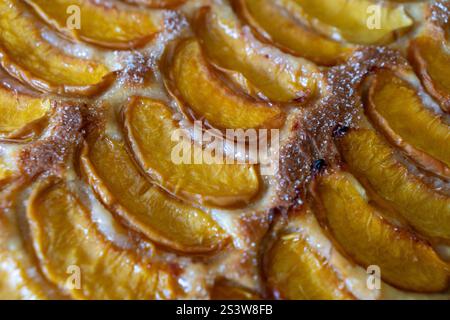 Ein Dessert aus geschnittenen Pfirsichen ist auf einem hölzernen Schneidebrett. Das Dessert ist mit Zucker bedeckt und sieht köstlich aus. Stockfoto