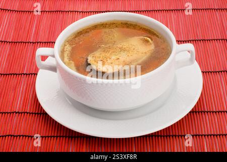 Suppe mit Lachs und Paprika auf rotem Hintergrund Stockfoto