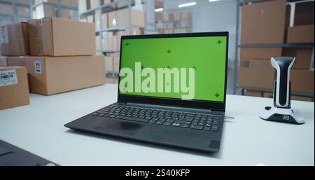 Postsortierzentrum: Auf Dem Laptop-Bildschirm Wird Ein Grüner Bildschirm Mit Chroma Key Angezeigt. Pakete mit Online-Bestellungen in Kartons in den Regalen im Lagereinzelhandel. Tracking System of Delivery Service. Nahaufnahme Stockfoto