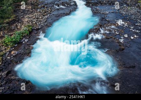 Der türkisfarbene Bruarfoss-Wasserfall fließt im Sommer in Island schnell über die Wildnis Stockfoto