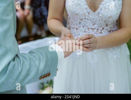 Die Braut legt einen Ring auf den Finger des Bräutigams, Ehemann und Frau. Hochwertige Fotos Stockfoto