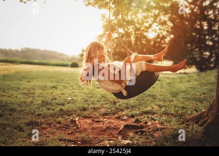 Sommerschaukel mit Welpen in einer Reifenschaukel Stockfoto
