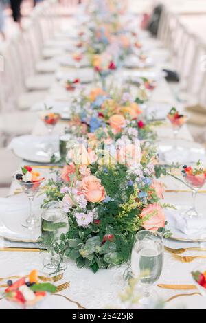 Herzstück des Tischs mit Blumenmuster und pfirsichfarbenen Rosen bei einem eleganten Brunch. Stockfoto