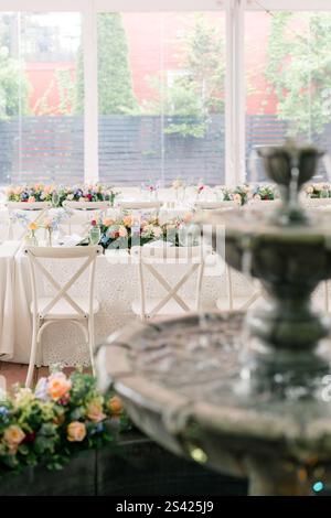 Außenempfang mit Blumentischen und einem fließenden Brunnen. Stockfoto