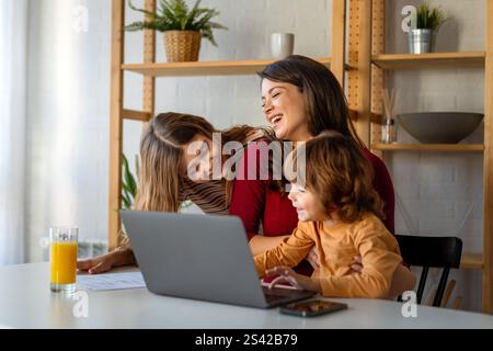 Frau genießt digitale Geräte mit ihren Kindern und verbringt lustige Momente zu Hause. Stockfoto