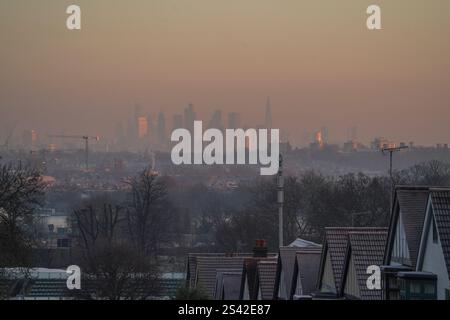 Wimbledon , London 10 Januar 2025 Wohndächer in Wimbledon, Südwesten Londons, bedeckt mit Frost und Blick auf die Skyline der Stadt London unter einem rosa Himmel bei Sonnenaufgang . Das Met Office gibt weitere gelbe Wetterwarnungen für Eis und Schnee mit Temperaturen von bis zu -15 Celsius aus, da Großbritannien seine bisher kälteste Nacht des Jahres verzeichnet hat und in den kommenden Tagen mehr Gefriertemperaturen erwartet werden. Credit.Amer Ghazzal/Alamy Live News Stockfoto