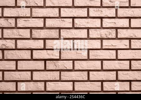 Detaillierte Ansicht einer Ziegelmauer in Mokka-Mousse, die die natürliche Textur und warme Farbtöne hervorhebt. Stockfoto