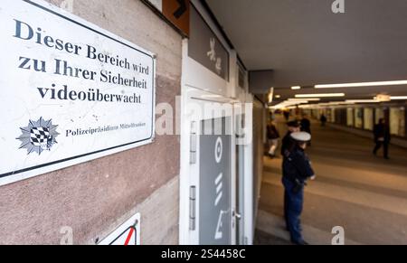 Nürnberg, Deutschland. Januar 2025. Ein Schild mit der Aufschrift „dieser Bereich wird zu Ihrer Sicherheit videoüberwacht“ hängt am Eingang einer Einkaufspassage am Nürnberger Hauptbahnhof. Auf einer Presseveranstaltung informierte die Polizei über Sicherheitsmaßnahmen am Nürnberger Hauptbahnhof. Vermerk: Daniel Karmann/dpa/Alamy Live News Stockfoto