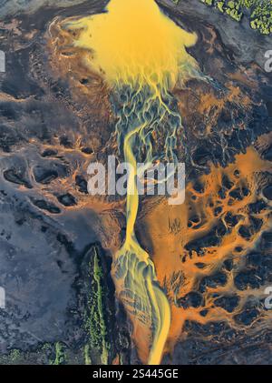 Aus der Vogelperspektive isländischer geflochtener Flüsse in lebhaften Gelb- und Orangetönen, die faszinierende abstrakte Muster in einer dramatischen Vulkanlandschaft bilden. Stockfoto