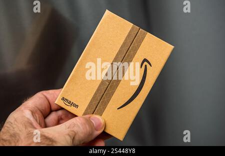 Paris, Frankreich – 22. November 2021: Kleine Kartonverpackung mit Amazon-Logo in der Hand, mit minimalistischem Verpackungsdesign und sicherer Faltung Stockfoto