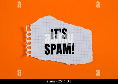 Es ist eine Spam-Nachricht, geschrieben auf gerissenem, kariertem Papier mit orangem Hintergrund. Konzeptionell ist das Spam-Symbol. Kopierbereich. Stockfoto
