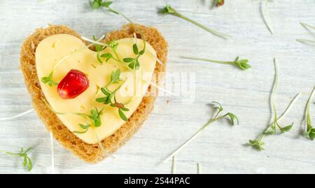 Herzförmige Minikanapees mit Butter, Käse und Brunnenkresse auf weißem Holzhintergrund. Blick von oben. Hochwertige Fotos Stockfoto