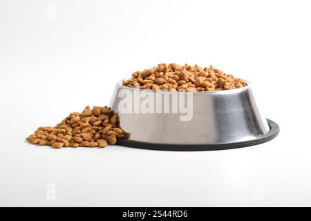 Trockenfutter für Katzen in Schüssel isoliert auf weißem Hintergrund. Braunes Katzenfutter Stockfoto