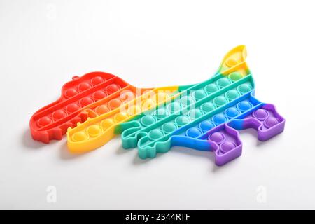 Rainbow Pop IT Spielzeuge in Regenbogenfarben und Dinosaurierformen. Bunte Push Pop It Bubble Sensorische Zappeln Spielzeug. Anti-Angst- und Stress-Entlastungsspiel Stockfoto