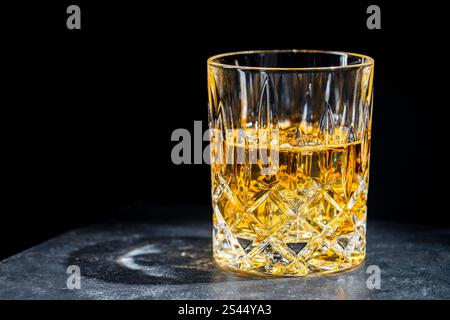 Kristallglas Whiskey mit Eiswürfeln auf schwarzem Hintergrund, Nahaufnahme, Kopierraum Stockfoto