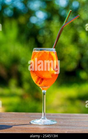 Aperol spritzt Cocktail in Weinglas auf einem Naturhintergrund. Klassischer italienischer Aperitif aperol Spritz-Cocktail mit Orangen- und Eiswürfeln. Nahaufnahme, Kopieren Stockfoto