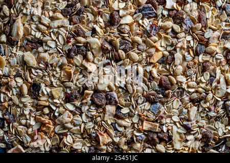Vollkorn-Hafermüsli mit getrockneten Früchten, Nüssen, Rosinen und Beeren, Draufsicht, Nahaufnahme. Hintergrund von Bio-Müsli zum Frühstück Stockfoto