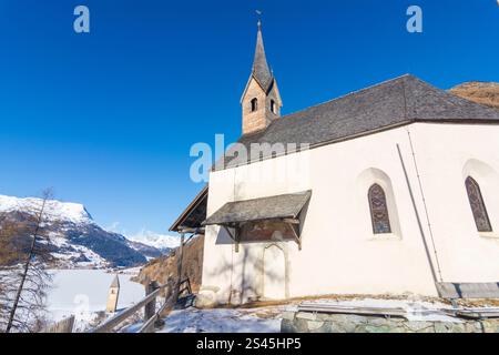 Graun im Vinschgau: Kapelle Annakapelle, gefrorener Reschensee mit untergetauchtem Kirchturm der Kirche Alt-Graun im Vinschgau, Trentino-Südtirol, Italien Stockfoto