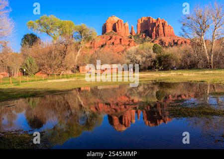 Eine wunderschöne Landschaft mit einem Haus und einem Teich. Der Teich spiegelt das Haus und die Berge im Hintergrund wider Stockfoto