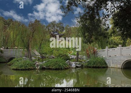 Der See der reflektierten Fragance, der Sternenschauturm und die Jade Ribbon Bridge umgeben von Bäumen und Pflanzen in den Chinesischen Gärten am Huntingt Stockfoto