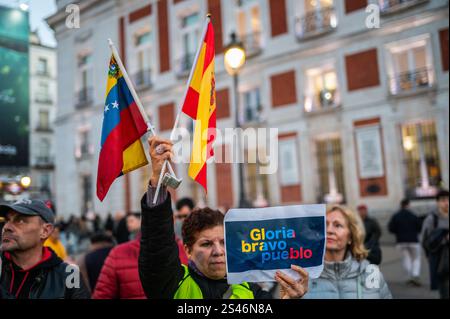 Madrid, Spanien. Januar 2025. Eine Frau hält die Flagge Venezuelas und die Flagge Spaniens. Die in Madrid lebenden Venezolaner haben sich in Puerta del Sol versammelt, um die Oppositionsführer Edmundo Gonzalez und Maria Corina Machado zu unterstützen und Präsident Nicolas Maduro am Tag der Amtseinführung des venezolanischen Präsidenten abzulehnen. Quelle: Marcos del Mazo/Alamy Live News Stockfoto