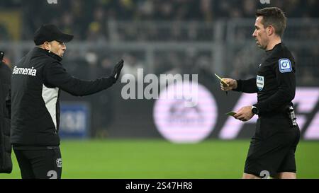 Dortmund, Deutschland. Januar 2025. Fußball, Bundesliga, Borussia Dortmund - Bayer Leverkusen, Spieltag 16, Signal Iduna Park, Leverkusens Assistenztrainer Sebastian Parrilla (l) wird von Schiedsrichter Tobias Stieler eine gelbe Karte gezeigt. WICHTIGER HINWEIS: Gemäß den Vorschriften der DFL Deutscher Fußball-Liga und des DFB Deutscher Fußball-Bundes ist es verboten, im Stadion und/oder im Spiel aufgenommene Fotografien in Form von sequenziellen Bildern und/oder videoähnlichen Fotoserien zu verwenden oder zu verwenden. Quelle: Bernd Thissen/dpa/Alamy Live News Stockfoto
