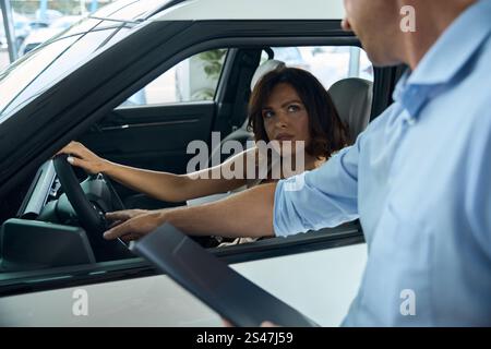 Geschäftswagenverkäufer, der mit weiblichen Kunden arbeitet Stockfoto
