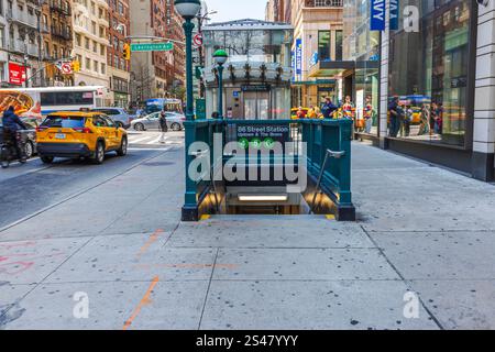 Eingang zur 86th Street Station mit grünem U-Bahn-Schild und geschäftiger städtischer Umgebung, einschließlich Autos und Fußgänger. New York. USA. Stockfoto