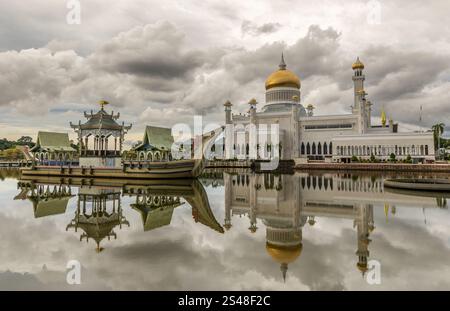 Weiße Omar Ali Saifuddien Moschee, goldene Kuppeln und Minarette mit Lagune und zeremoniellen Steinkahn Schiff im Wasser gespiegelt, Bandar Seri Begawan, Bor Stockfoto