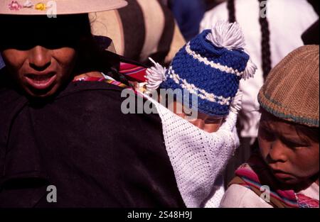 Frau mit einem Baby in ein traditionelles Tuch gewickelt auf dem Tarabuco Market in Bolivien, wo lokale Kultur und traditionelle Kleidung präsentiert werden. Stockfoto
