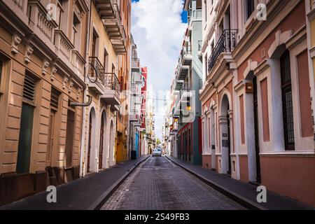 San Juan, Puerto Rico - 25. Februar 2018: Ein Auto ragt auf der schmalen, kopfsteingepflasterten, farbenfrohen Calle Tetuan in Old San Juan herunter. Stockfoto