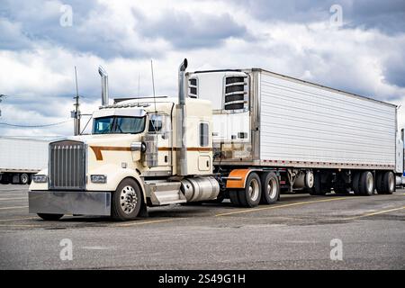 Industrieller beigefarbener Großfahrzeug-Sattelzugmaschine mit verlängerter Kabine für den LKW-Fahrer, der an markierter Stelle steht Stockfoto