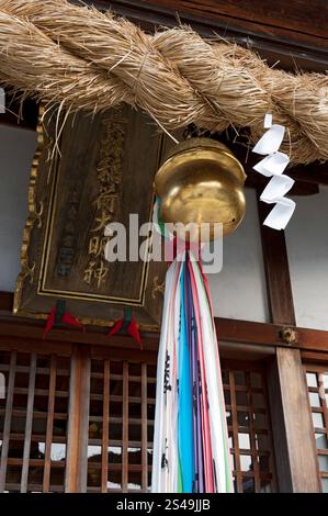 Typische Shinto-Schrein-Objekte: Shimenawa (verdrehtes Seil), shide (Zickzack-Papierstreamer) und suzu (runde Hohlglocke), die überall in Japan zu sehen sind. Stockfoto