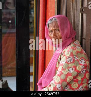 Eine schöne alte Frau in einem rosafarbenen Kleid mit einem rosa Hijab oder Kopftuch in Bukittinggi, West Sumatra, Indonesien. Stockfoto