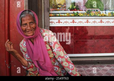 Eine schöne alte Frau in einem rosafarbenen Kleid mit einem rosa Hijab oder Kopftuch in Bukittinggi, West Sumatra, Indonesien. Stockfoto