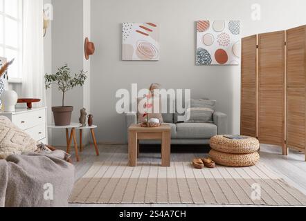 Wohnzimmereinrichtung mit Ikebana auf Tisch und Sofa Stockfoto