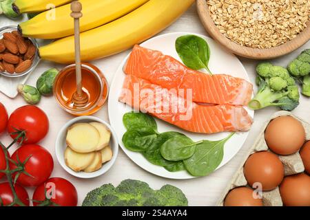 Verschiedene Produkte reich an Melatonin auf weißem Holztisch, flach gelegt Stockfoto