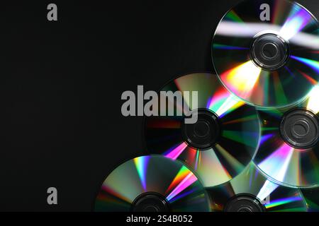 Glänzende CDs auf schwarzem Hintergrund, Draufsicht. Leerzeichen für Text Stockfoto
