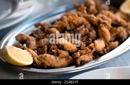 Ein Teller mit frittierten kleinen, köstlichen Tintenfischen, gegrillten Meeresfrüchten aus der Nähe. Stockfoto