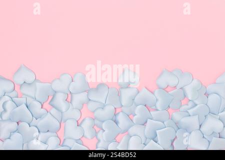 Blaues Textil-Herz-Konfetti auf rosa Pastellhintergrund. Kreative Komposition mit Copyspace. Stockfoto