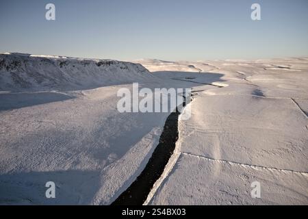 Der Fluss Tees, der unterhalb der zerklüfteten Flanken von Cronkley fließt, fiel mit Blick in Richtung Meldon Hill, die Dun Fells und Cross Fell im Winter, Upper Teesd Stockfoto