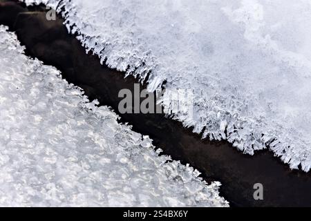 Eiskristalle, die sich im Winter entlang der Kante eines Baches bilden, North Pennines, Teesdale, County Durham, Großbritannien Stockfoto