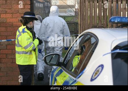 Swancote Road, Dudley 11. Januar 2025 - die Polizei der West Midlands am Tatort eines Mordes an der Swancote Road in Dudley. Polizisten haben einen Mann wegen Mordverdacht verhaftet, nachdem heute (11. Januar) ein weiterer Mann tot im Wohnblock in Dudley aufgefunden wurde. Eine kleine Kordon umgibt das Anwesen mit einem Beweismarker neben einer Blutspur draußen. Forensiker wurden gesehen, wie sie Beweismittel vom Grundstück wegnahmen. In einer Polizeierklärung der West Midlands heißt es weiter: „Wir wurden kurz vor 2.30 Uhr von Ambulanzkollegen zur Swancote Road gerufen. „Ein Mann in seinen 40ern wurde mit Verletzungen und gefunden Stockfoto