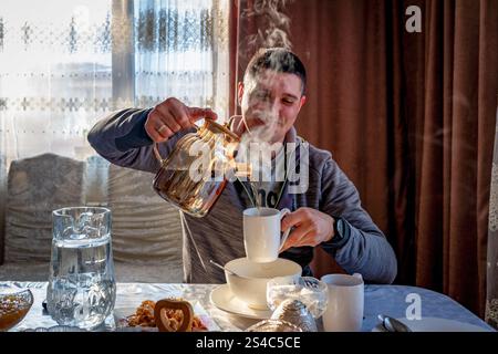 25. Dezember 2024, Almaty, Kasachstan: Ein kasachischer Mann wird beim Gießen von heißem Tee in einem Gästehaus in Saty, Kasachstan, gesehen. Das Binnenland ist im Winter oft von extremer Kälte heimgesucht. (Credit Image: © Jasmine Leung/SOPA Images via ZUMA Press Wire) NUR REDAKTIONELLE VERWENDUNG! Nicht für kommerzielle ZWECKE! Stockfoto