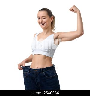 Gewichtsverlust. Glückliche Frau, die große Jeans auf weißem Hintergrund trägt Stockfoto