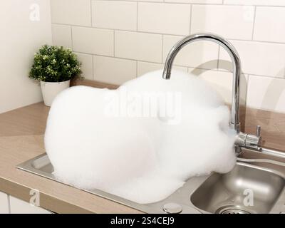 Schaum waschen, nachdem zu viel Seife in Küchenspüle verwendet wurde Stockfoto