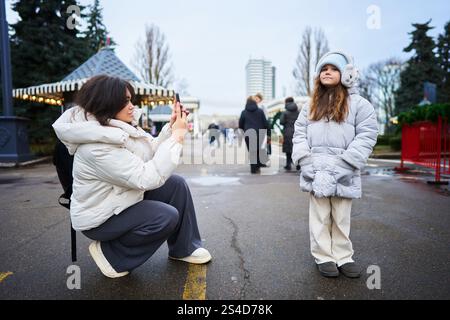 Mutter fängt einen freudigen Moment mit Tochter bei einem Outdoor-Event im Winter ein Stockfoto