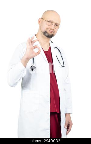 Ein glatzköpfiger Arzt mit einer Brille in weißem Labormantel und roten Peelings steht selbstbewusst mit einem Stethoskop um den Hals. Stockfoto