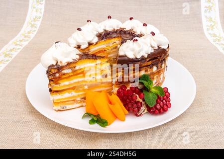 Ein lebhaftes Dessert in mehreren Schichten besteht aus abwechselnden Teilen von Kuchen, Obst und Sahne. Das Gericht ist wunderschön mit frischem Obst und einem Dekorativ präsentiert Stockfoto