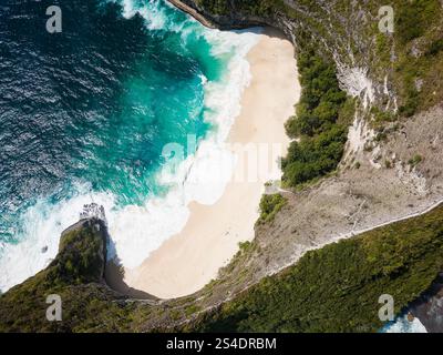 Luftaufnahme eines tropischen Strandes und Ozeans, umgeben von riesigen, hoch aufragenden Klippen (Nusa Penida) Stockfoto